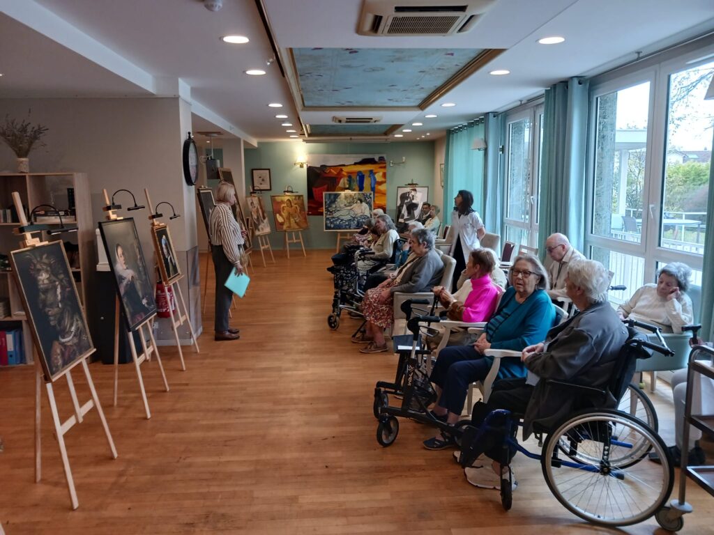 Personnes âgées regardant des peintures dans une galerie.