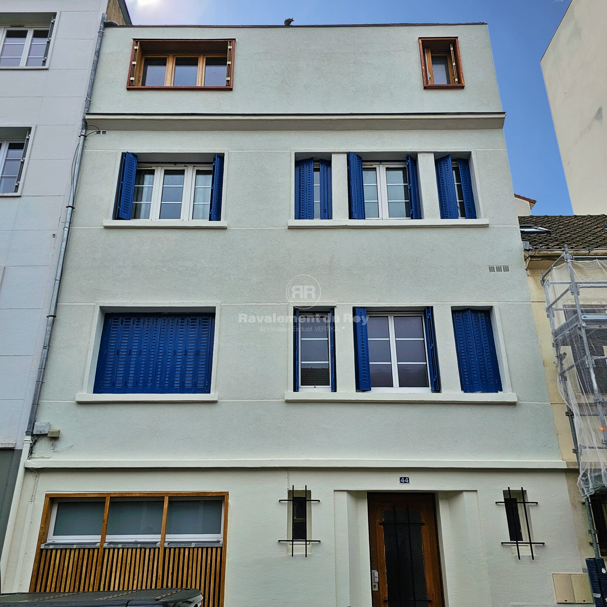 Façade d'immeuble rénovée avec volets bleus et fenêtres modernes