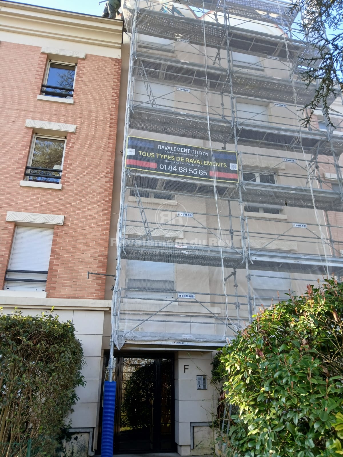 Façade en ravalement avec échafaudage et affiche Ravalement du Roy
