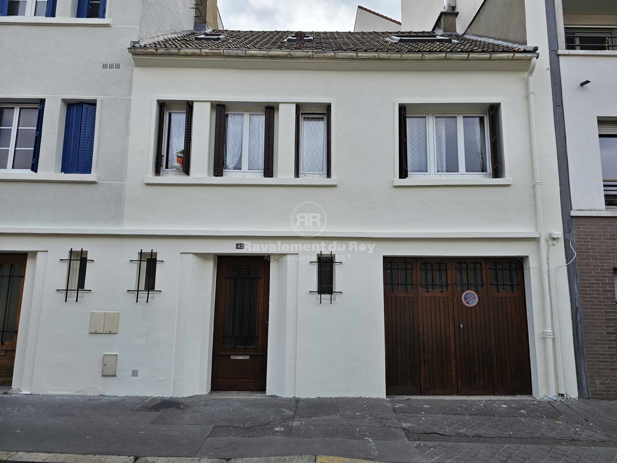 Façade résidentielle avec portes en bois et fenêtres après ravalement du Roy