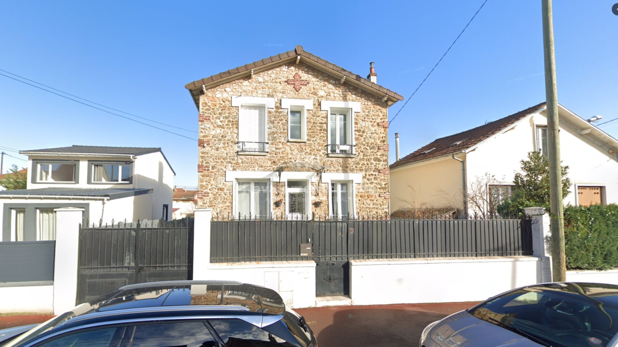 Maison en pierre avec façade en Ravalement du Roy et clôture en fer forgé