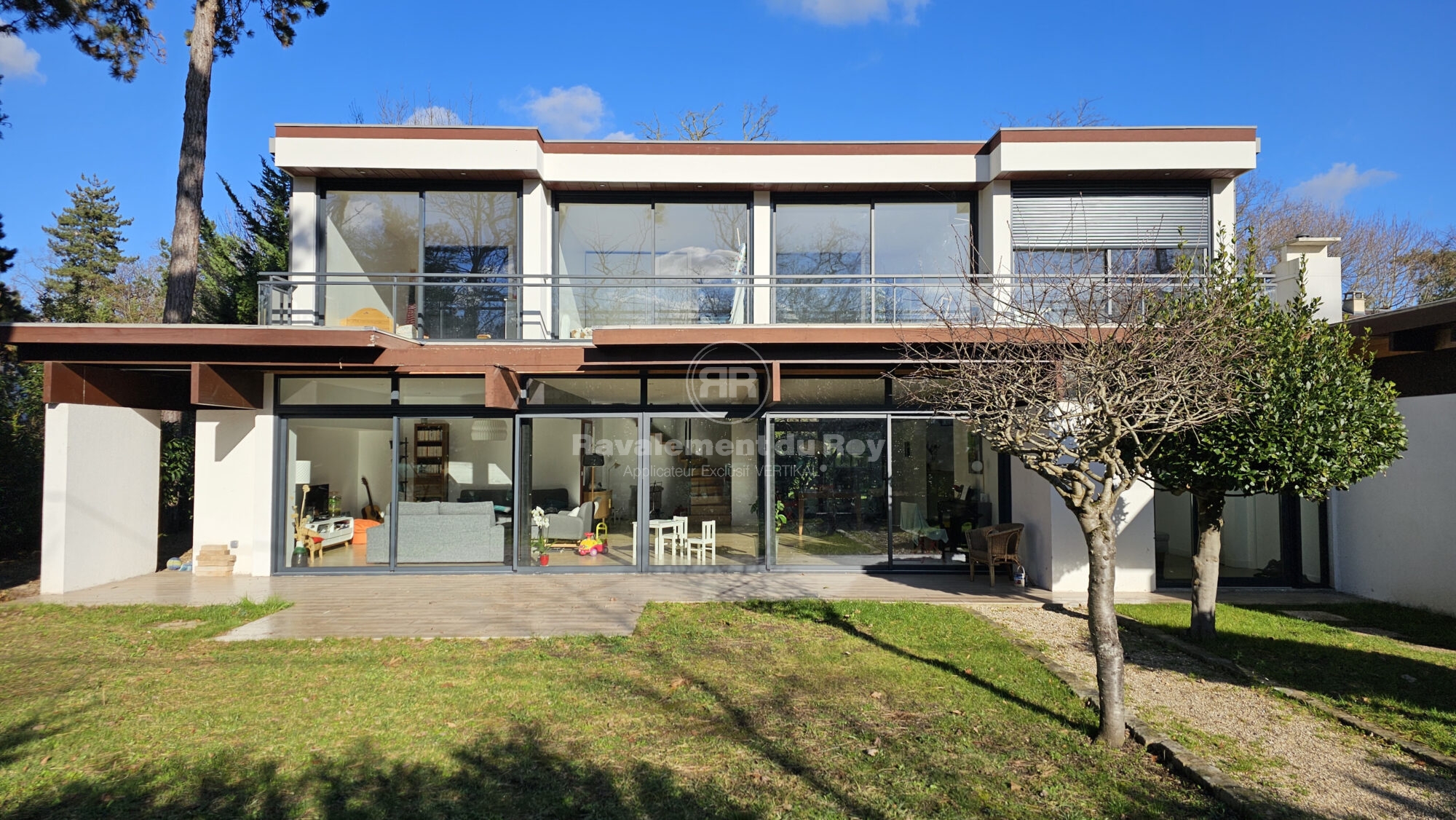 Maison moderne avec grandes baies vitrées et balcon en ravalement