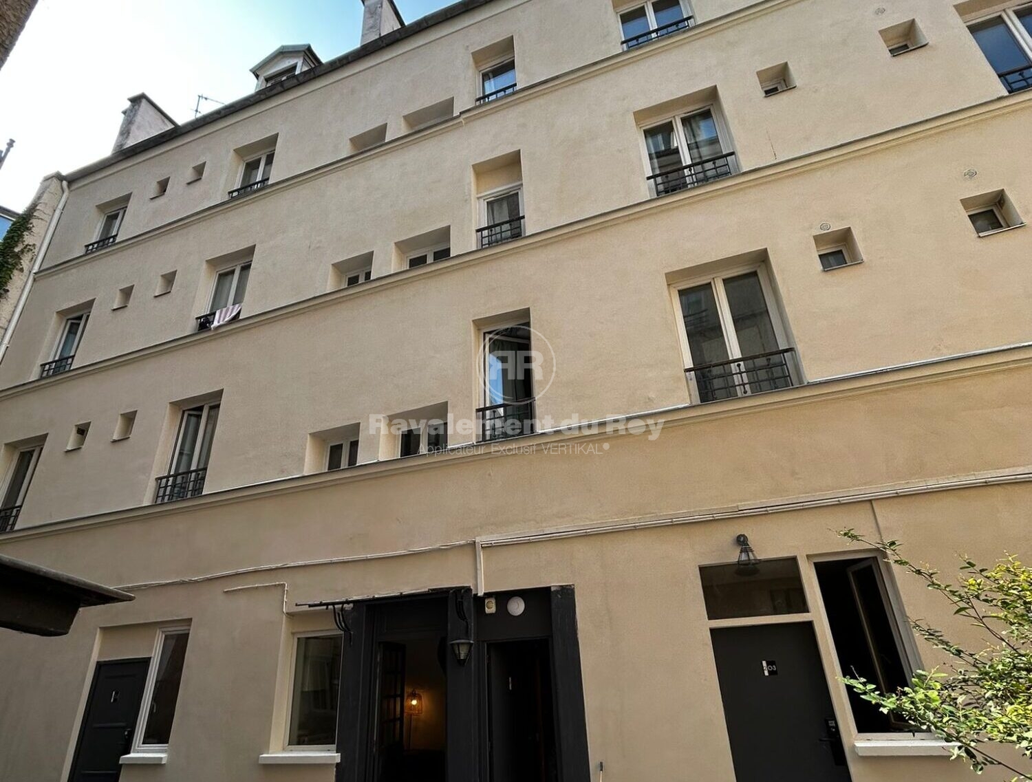 Façade d'un immeuble en cours de ravalement, entrées principales visibles