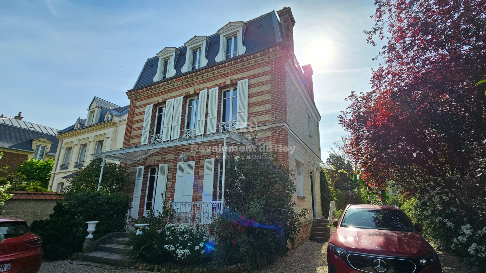 Maison en brique avec balcon après ravalement du Roy, jardin et voiture rouge