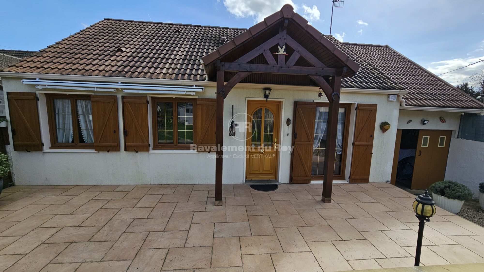 Maison avec façade rénovée et porte en bois, ravalement du Roy.