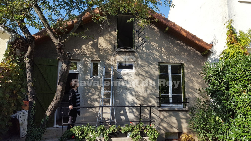 Femme devant maison en rénovation.