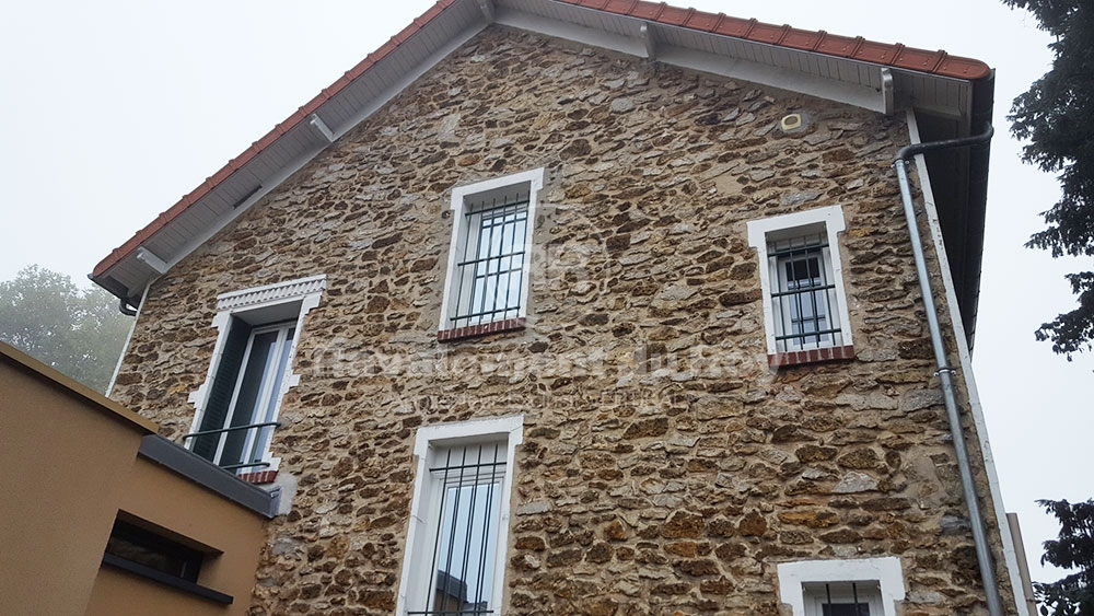 Ancienne maison en pierre avec fenêtres à barreaux